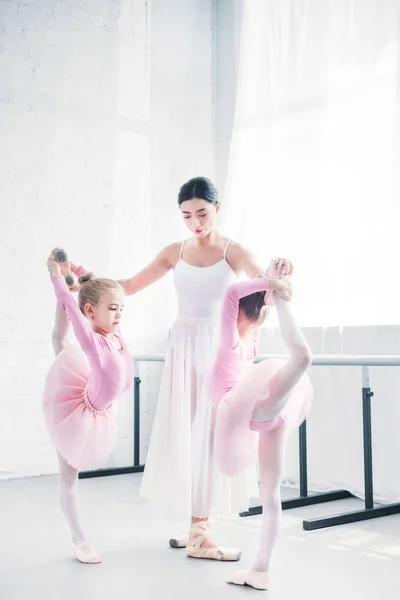 Молодой учитель балета готовит маленьких балерин в балетной школе — стоковое фото
