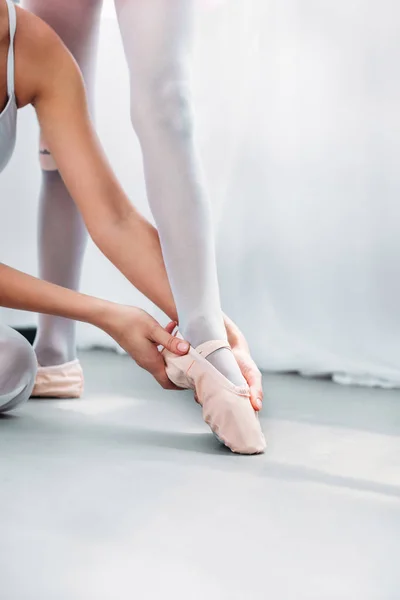 Tiro cortado de mulher exercitando-se com pequena bailarina em sapatos pointe — Fotografia de Stock