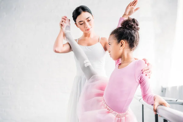 Hermosa pequeña bailarina afroamericana formación con el profesor en la escuela de ballet - foto de stock