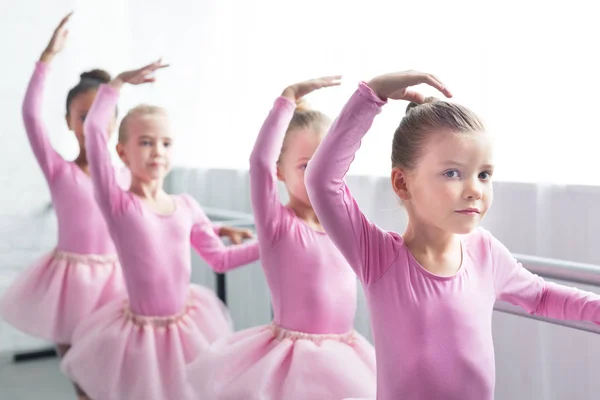 Crianças bonitas em saias tutu rosa dançando na escola de balé — Fotografia de Stock