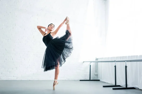 Visão de comprimento total da bela bailarina jovem elegante praticando balé no estúdio — Fotografia de Stock