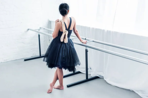 Visão de alto ângulo de jovens bailarina segurando sapatos de balé e olhando para longe — Fotografia de Stock