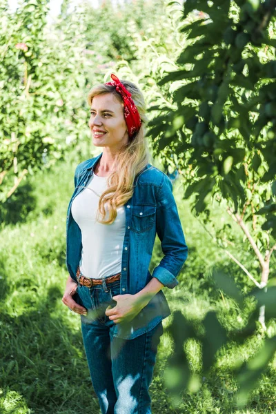 Attraktive Bäuerin schaut im grünen Garten am Bauernhof weg — Stockfoto