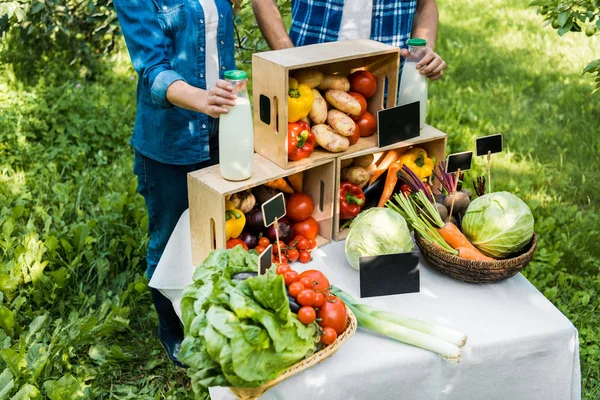 Immagine ritagliata di coppia di agricoltori impostazione bancarella al mercato contadino — Foto stock