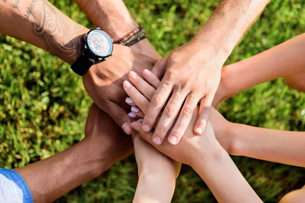 Cropped shot of multiracial friends holding hands together — Stock Photo