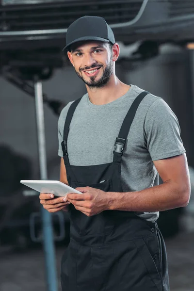 Mecânico automóvel profissional em macacão usando tablet digital — Fotografia de Stock