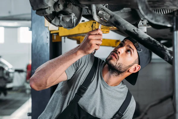 Obrero con equipo de reparación de coches en taller mecánico - foto de stock