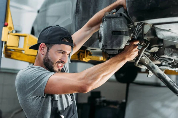 Ingeniero en overoles reparación de coches en taller mecánico - foto de stock