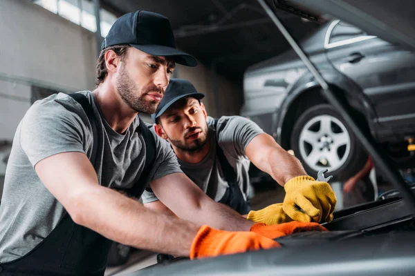 Operai riparano auto in officina meccanica — Foto stock