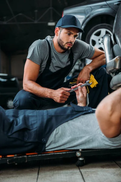 Professional engineers working with tools in auto repair shop — Stock Photo
