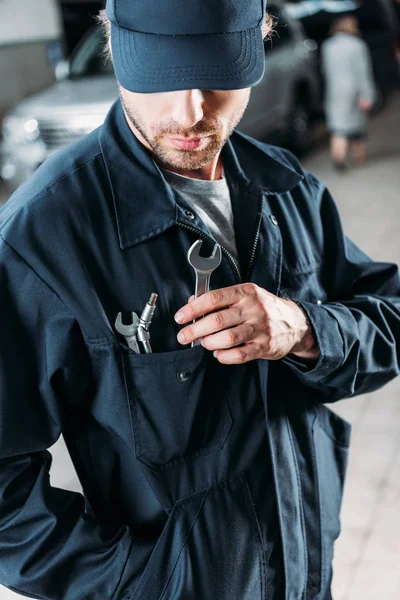 Workman in cap and overalls holding tools in pocket — Stock Photo