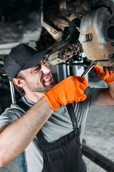 Mechaniker repariert Auto ohne Rad in Werkstatt — Stockfoto