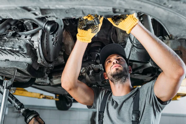 Professional mechanic repairing a car in auto repair shop — Stock Photo