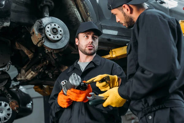 Auto mechanics working with car and tools in workshop — Stock Photo