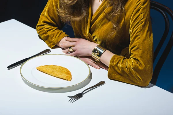 Vista parcial da mulher em roupas de luxo sentado à mesa com cheburek carne na placa com fundo azul — Fotografia de Stock