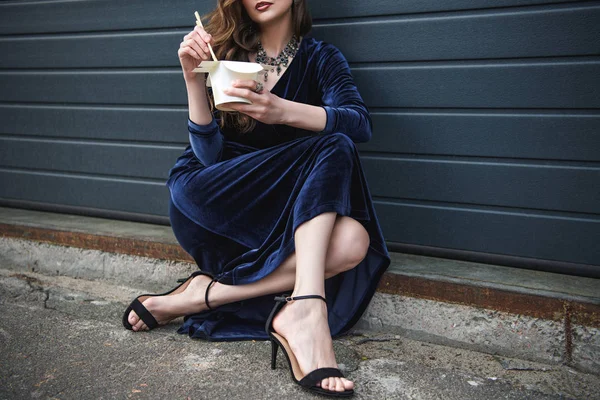 Partial view o fstylish woman in beautiful dress with asian takeaway food on street — Stock Photo