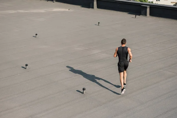 High angle view of sportsman running on roof — Stock Photo