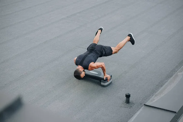 High angle view of sportsman training with step platform and standing on hands on roof — Stock Photo