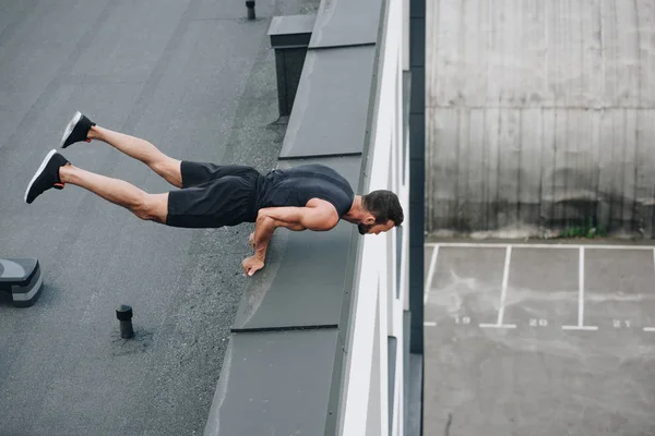 Visão de alto ângulo de treinamento desportivo e de pé sobre as mãos no telhado — Fotografia de Stock