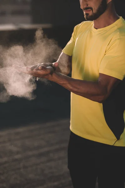 Immagine ritagliata di uomo sportivo battendo le mani con talco in polvere sul tetto — Foto stock