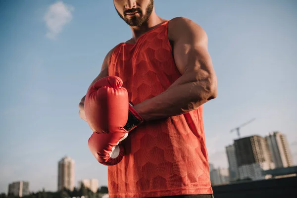 Imagen recortada de deportista atando guante de boxeo en el techo - foto de stock