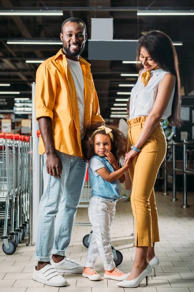 Young african american parents with little daughter in grocery store — Stock Photo