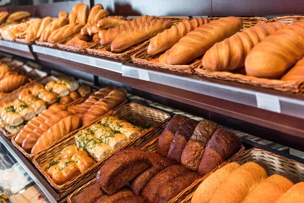 Selective focus of freshly baked various bread in pastry department of grocery store — Stock Photo