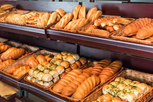 Enfoque selectivo de pan recién horneado varios en el departamento de pastelería del hipermercado - foto de stock