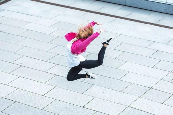 Hochwinkelaufnahme einer stilvollen Tänzerin, die auf der Stadtstraße springt — Stockfoto