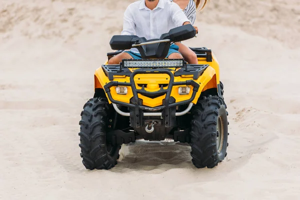 Recortado disparo de joven pareja activa montar vehículo todo terreno en el desierto - foto de stock