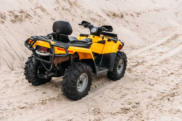 Yellow all-terrain vehicle parked on sand — Stock Photo