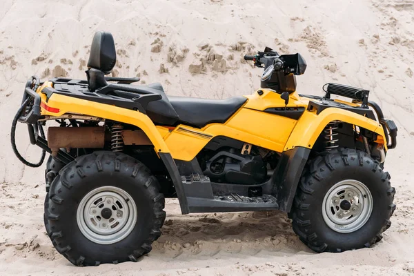 Vista laterale del moderno veicolo giallo all-terrain in piedi nel deserto nella giornata nuvolosa — Foto stock