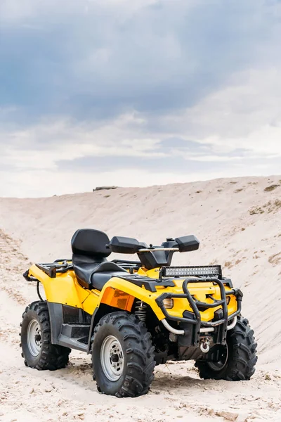 Vehículo todo terreno amarillo moderno de pie en el desierto en el día nublado - foto de stock