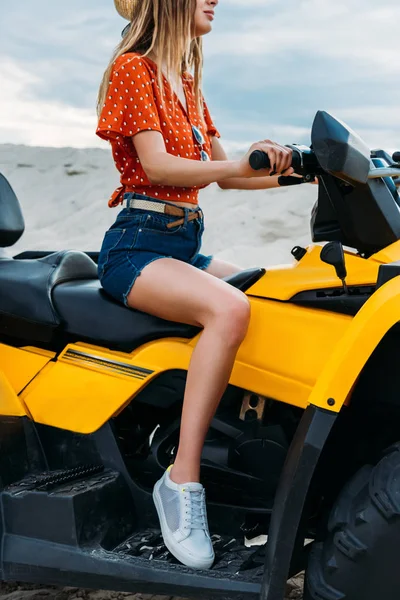 Colpo ritagliato di giovane donna seduta su veicolo all-terrain nel deserto — Foto stock