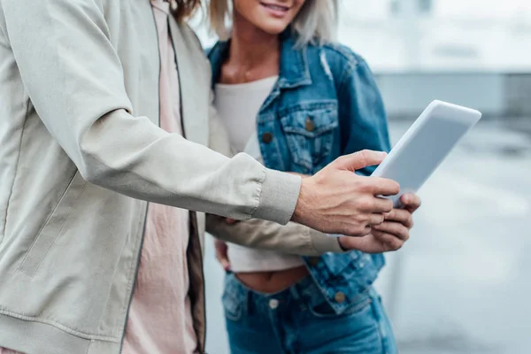 Plan recadré de jeune couple en utilisant la tablette ensemble sur la rue — Photo de stock