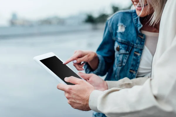 Ritagliato colpo di coppia utilizzando tablet con schermo vuoto insieme — Foto stock