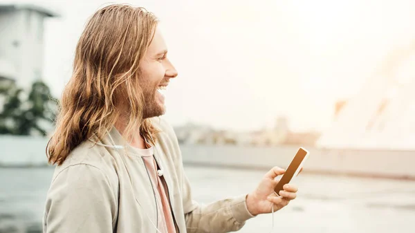 Ridendo giovane utilizzando smartphone sulla strada — Foto stock