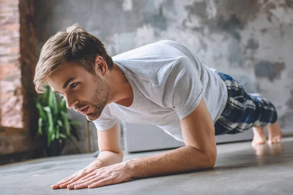 Homme sérieux faisant planche pendant le matin à la maison — Photo de stock