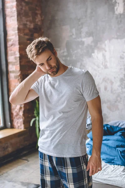 Young man wake up and standing near bed at home — Stock Photo