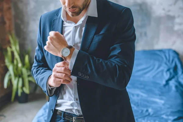Imagem cortada de homem de negócios em terno colocando relógio de pulso no quarto em casa — Fotografia de Stock