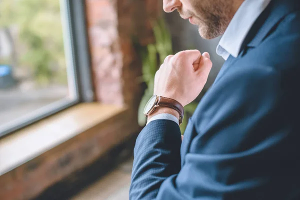 Imagen recortada de hombre de negocios que se pone el reloj de pulsera en casa - foto de stock