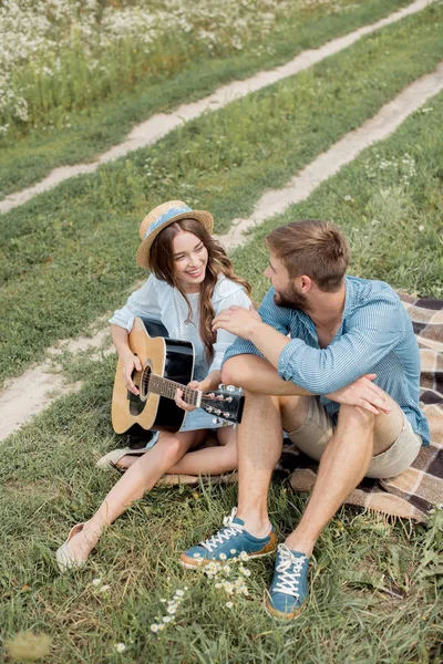 Mulher sorrindo tocando guitarra acústica para namorado no verão arquivado — Fotografia de Stock