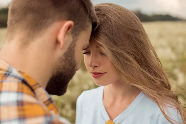 Retrato de los amantes tiernos de pie cara a cara en el campo - foto de stock