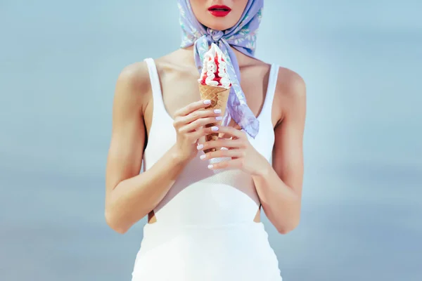 Vista ritagliata di ragazza in costume da bagno bianco vintage e sciarpa di seta che tiene il gelato in cono waffle — Foto stock