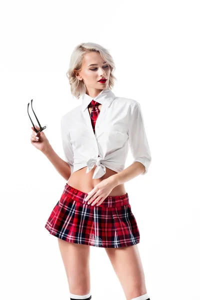 Retrato de mujer joven sexy en falda a cuadros colegiala corta con gafas posando aislado en blanco - foto de stock