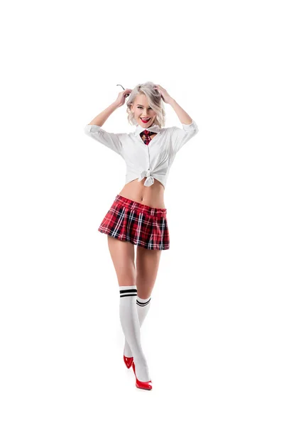 Sexy playful woman in short schoolgirl plaid skirt and knee socks with eyeglasses posing isolated on white — Stock Photo