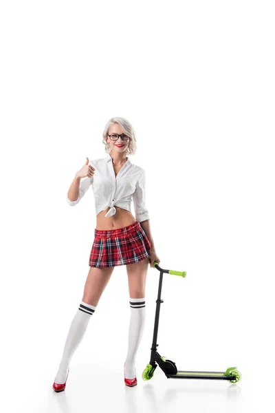 Sexy woman in college short plaid skirt in eyeglasses with scooter showing thumb up isolated on white — Stock Photo