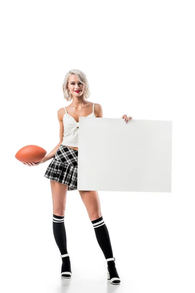 Sexy mujer rubia en falda corta a cuadros con bola de rugby y pancarta vacía posando aislado en blanco - foto de stock