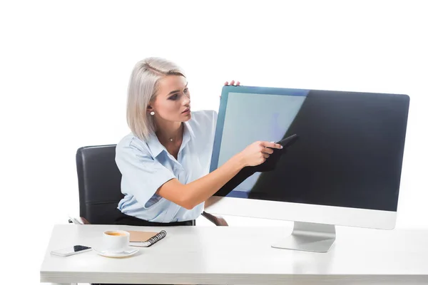 Retrato de la mujer de negocios apuntando a la pantalla en blanco de la computadora en el lugar de trabajo aislado en blanco - foto de stock