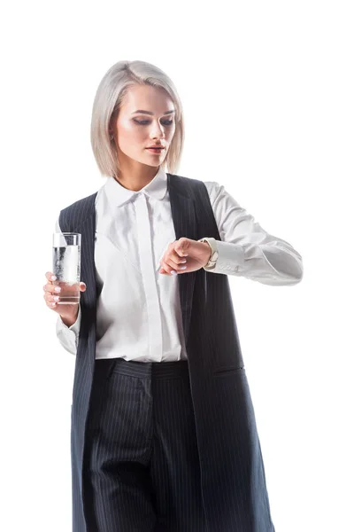 Ritratto di donna d'affari con bicchiere d'acqua in mano controllando il tempo isolato su bianco — Foto stock